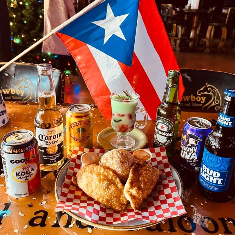 Fried empanadas, a green drink, and various beers and sodas with a Puerto Rican flag.